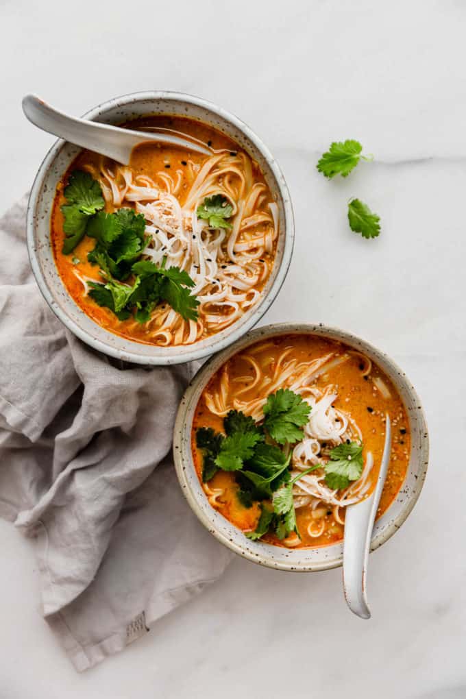 two bowls of Thai coconut soup topped with cilantro