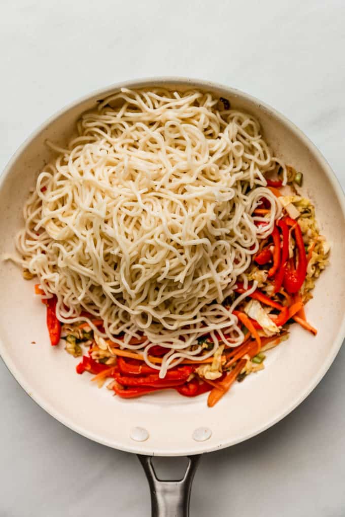 a white pan with noodles and vegetables in it