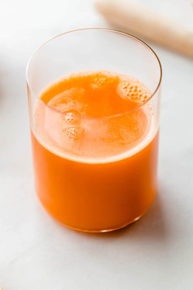 A glass of orange carrot and ginger juice