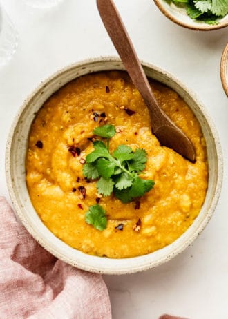red lentil dahl in a ceramic bowl topped with cilantro