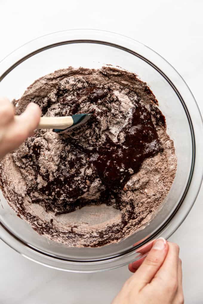 a hand mixing brownie batter with a spatula