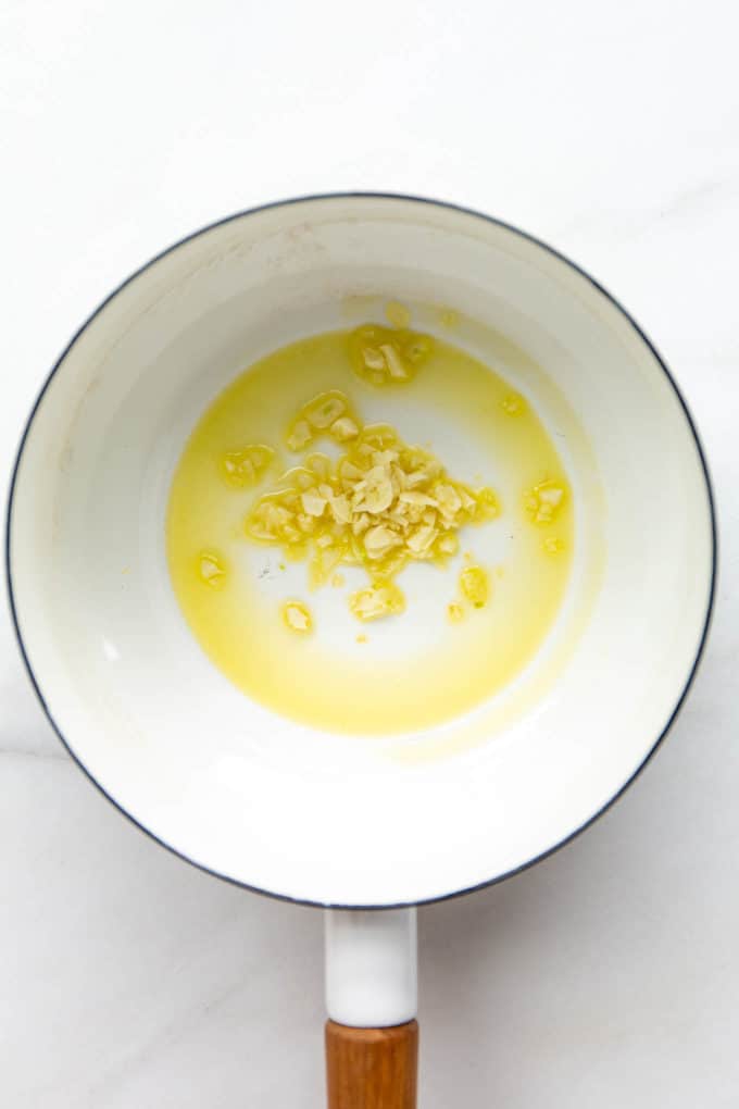 garlic sautéing in a white pot