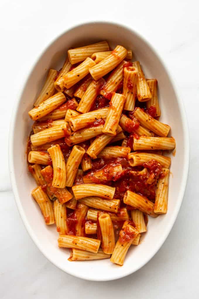 ziti noodles and tomato sauce in a baking dish