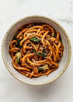 A bowl of yaki udon noodles topped with sesame seeds