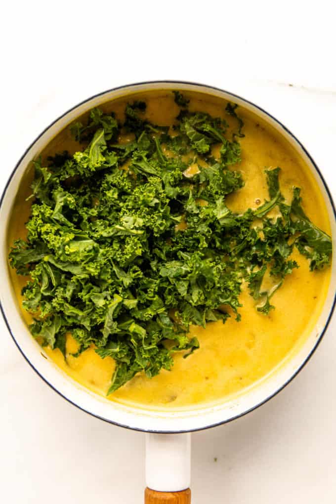 Chopped kale in a pot with chickpea soup