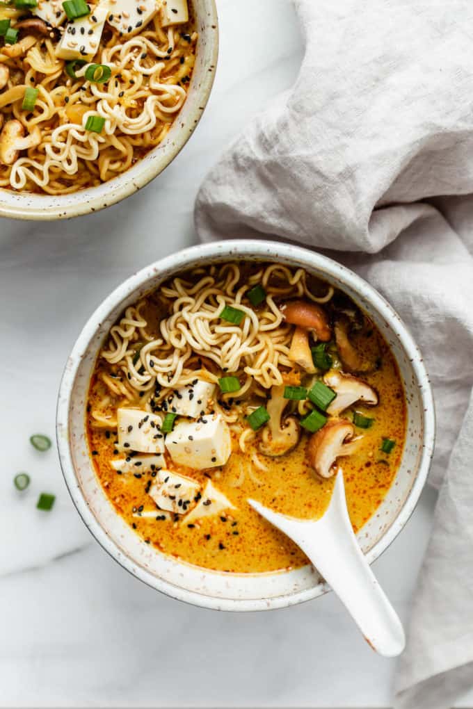 a bowl of coconut curry ramen with tofu, mushrooms and noodles
