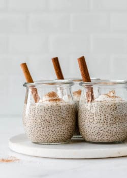 three jars filled with eggnog chia pudding topped with yogurt