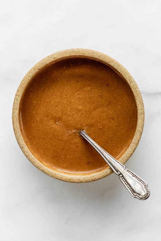 Thai peanut sauce in a small bowl with a spoon in it