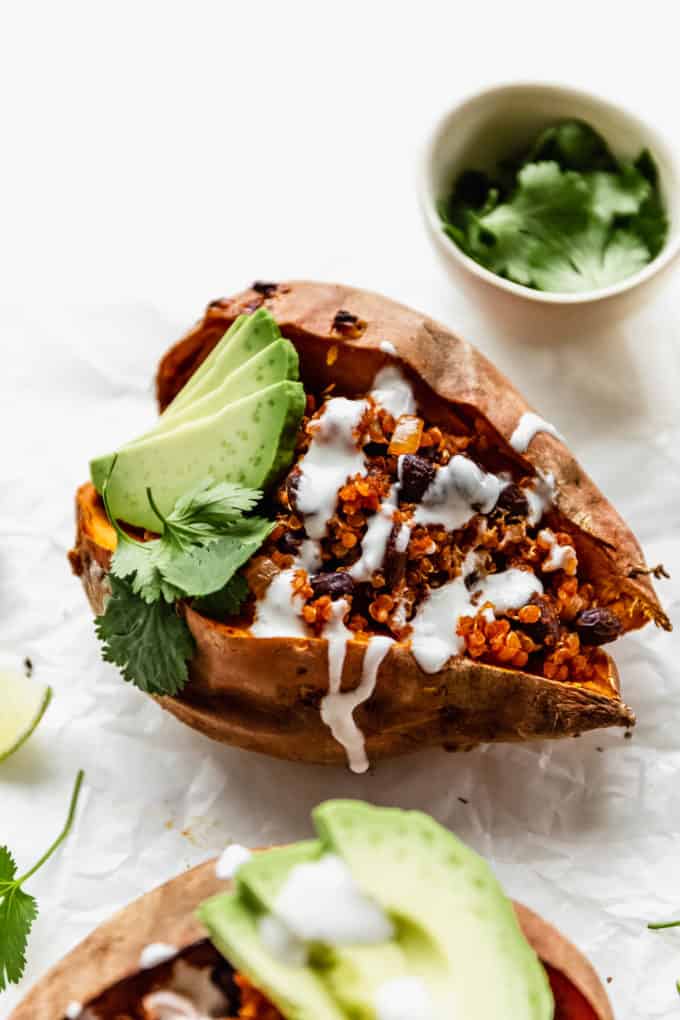 sweet potatoes stuffed with black beans and quinoa topped with avocado