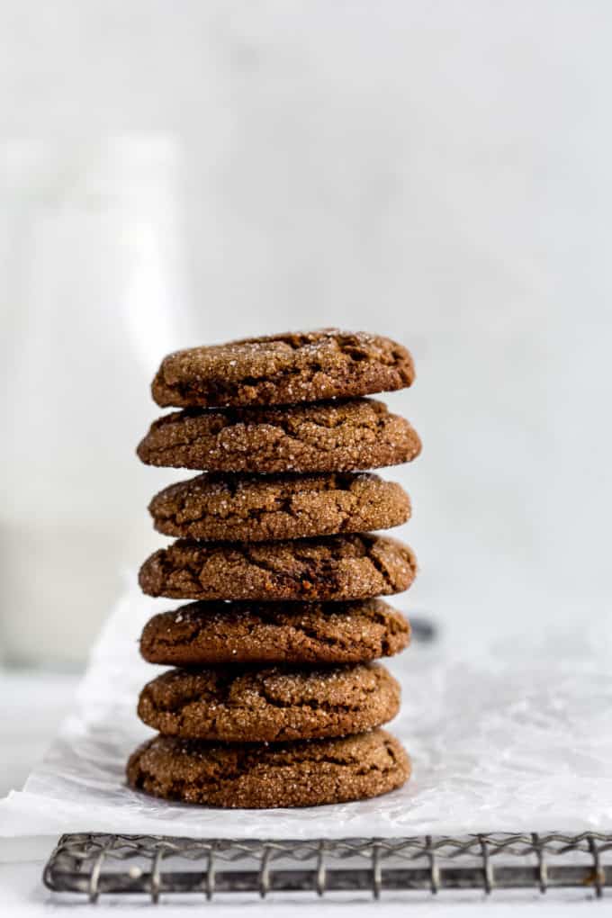 Ginger molasses cookies stacked on a cooling rack