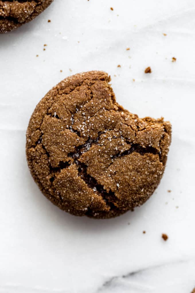 A ginger molasses cookie with a bite taken out of it