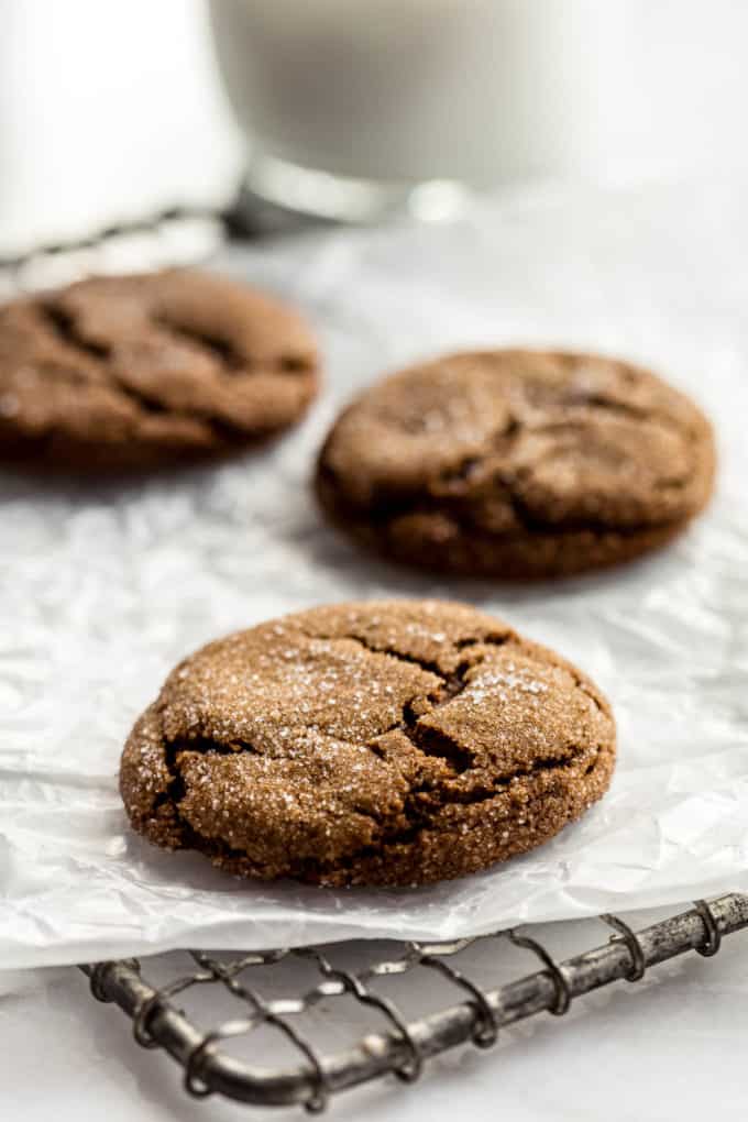 three ginger molasses cookies on parchment paper on a cooling rack