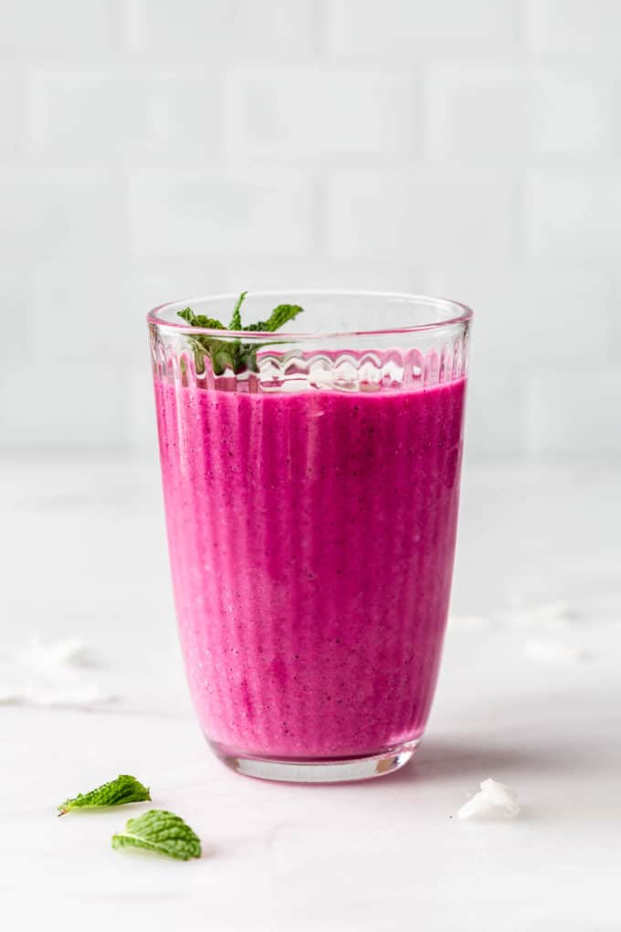 a glass of dragon fruit smoothie on a marble counter