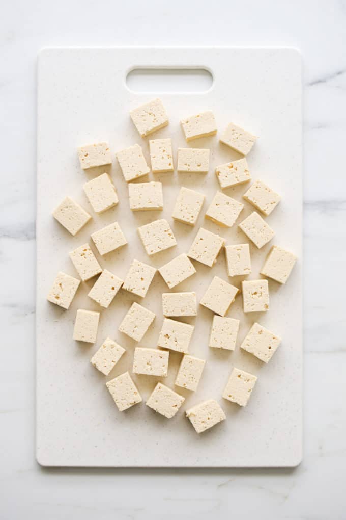 cubes of tofu on a whit cutting board