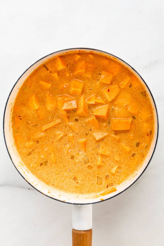uncooked sweet potato curry in a white pot
