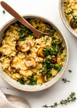 Vegan mushroom risotto in a bowl topped with chopped parsley