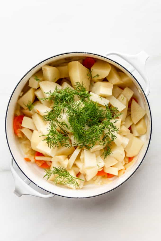 Cut up potatoes and dill in a white pot
