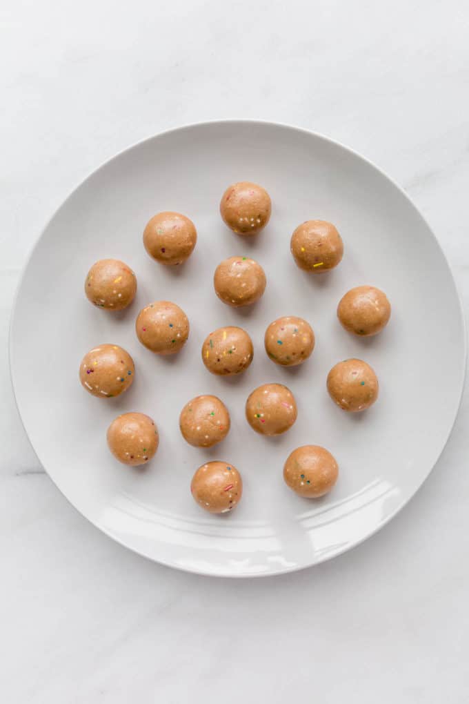 birthday cake protein balls on a white plate