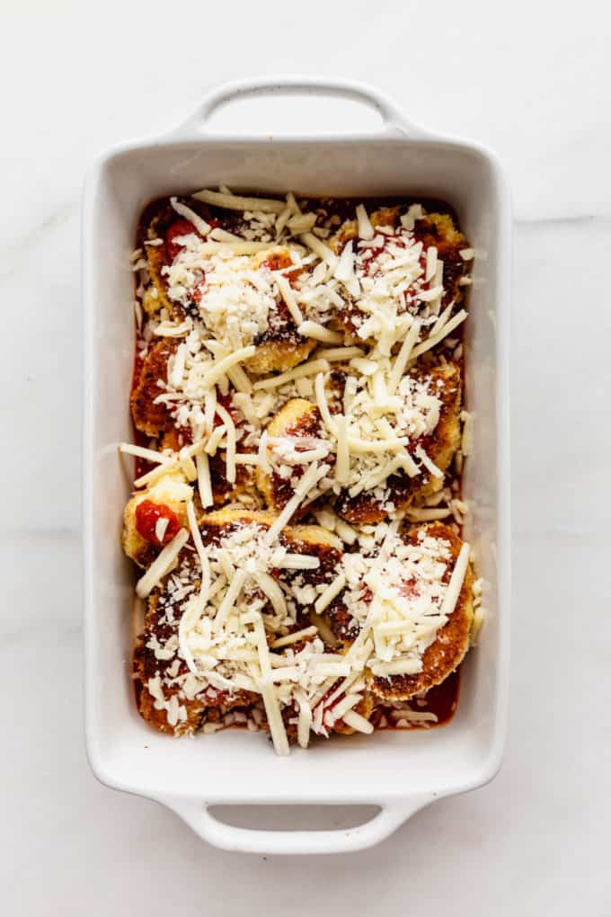cauliflower in a white baking dish topped with shredded cheese