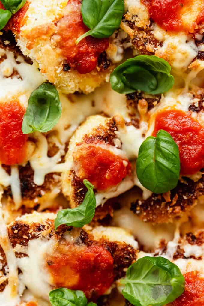 cauliflower topped with cheese, tomato sauce and basil leaves
