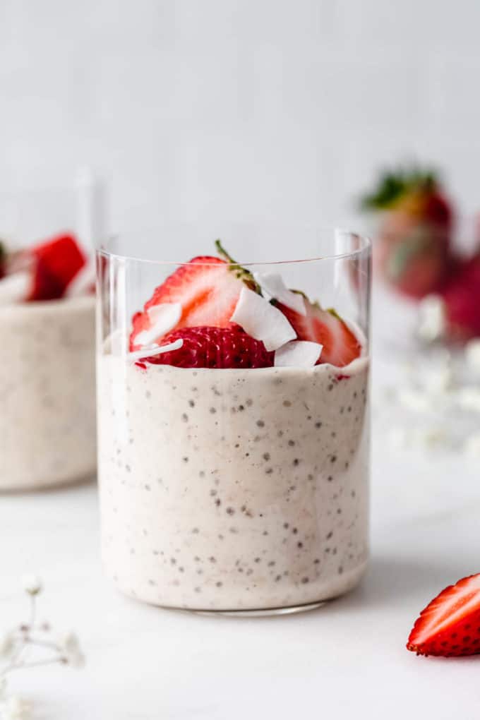 a glass of protein overnight oats topped with strawberries