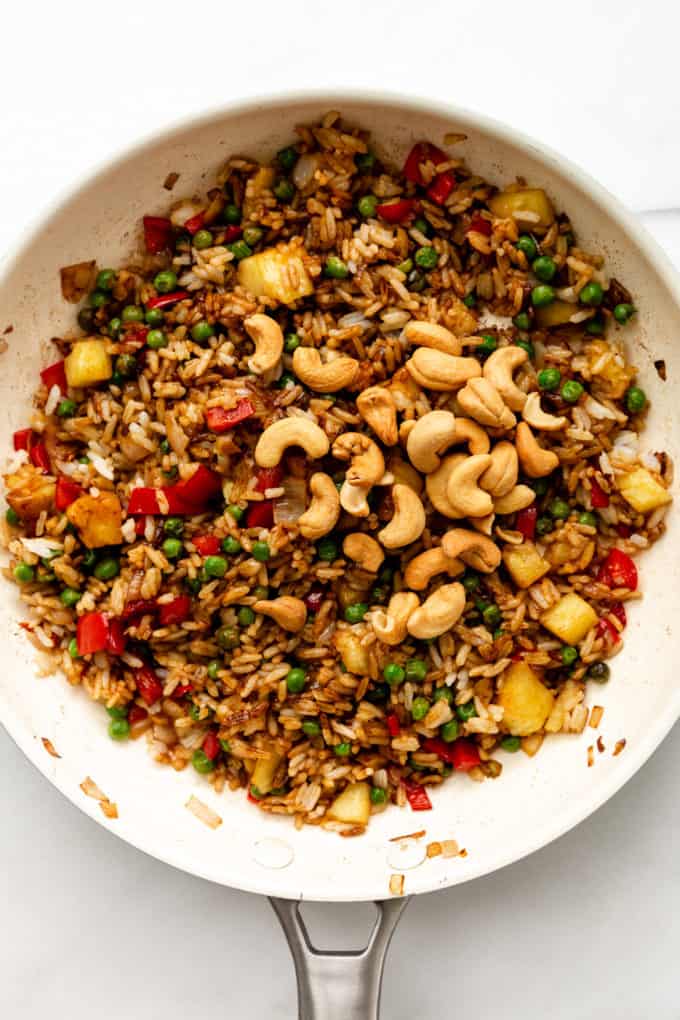 fried rice topped with cashews in a pan