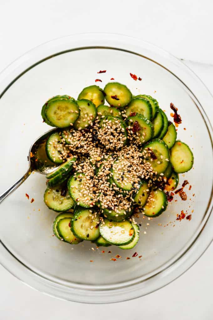 Asian cucumber salad in a mixing bowl topped with sesame seeds