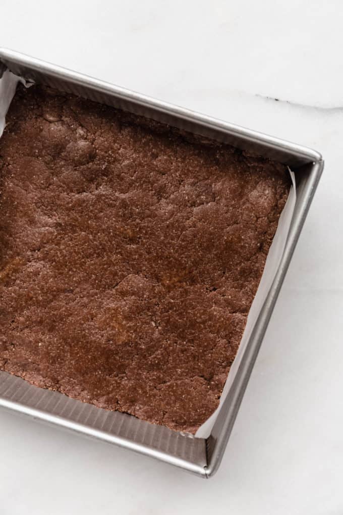 chocolate protein bar dough pressed into an 8x8 inch pan