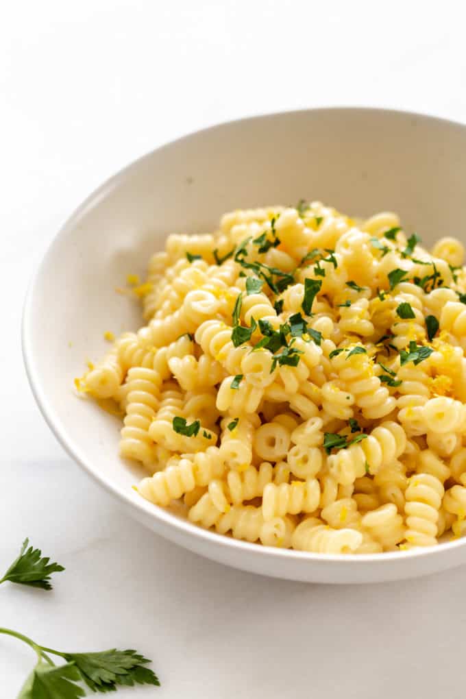 Lemon fusilli pasta in a white bowl with parsley