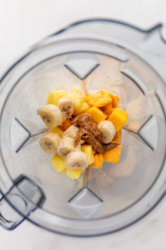 mango, banana, pineapple and almond butter in a blender