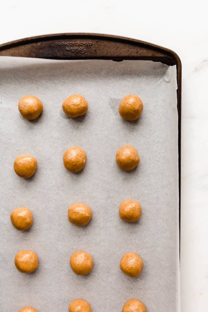 peanut butter cookie dough balls on a baking sheet