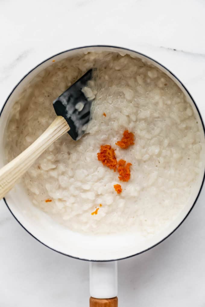rice pudding in a white pot with orange zest