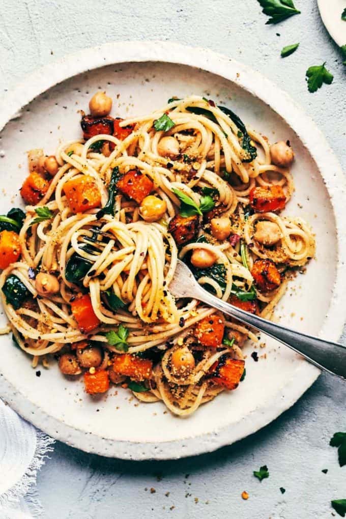 spaghetti with roasted butternut squash and chickpeas on a white plate