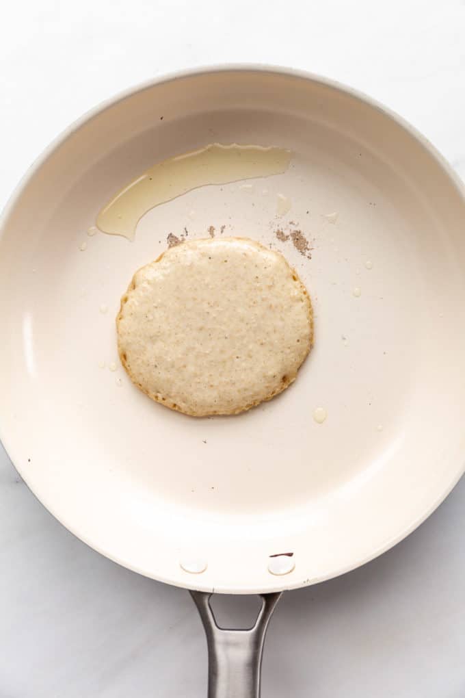 oat flour pancake uncooked in a white pan