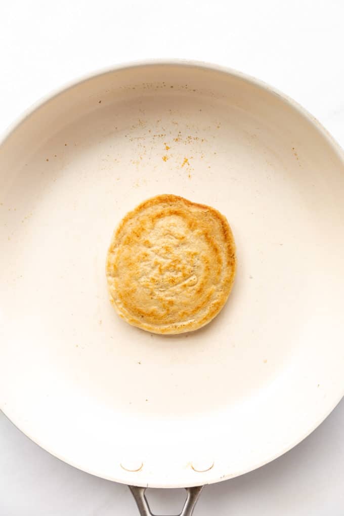 a cooked oat flour pancake in a white pan