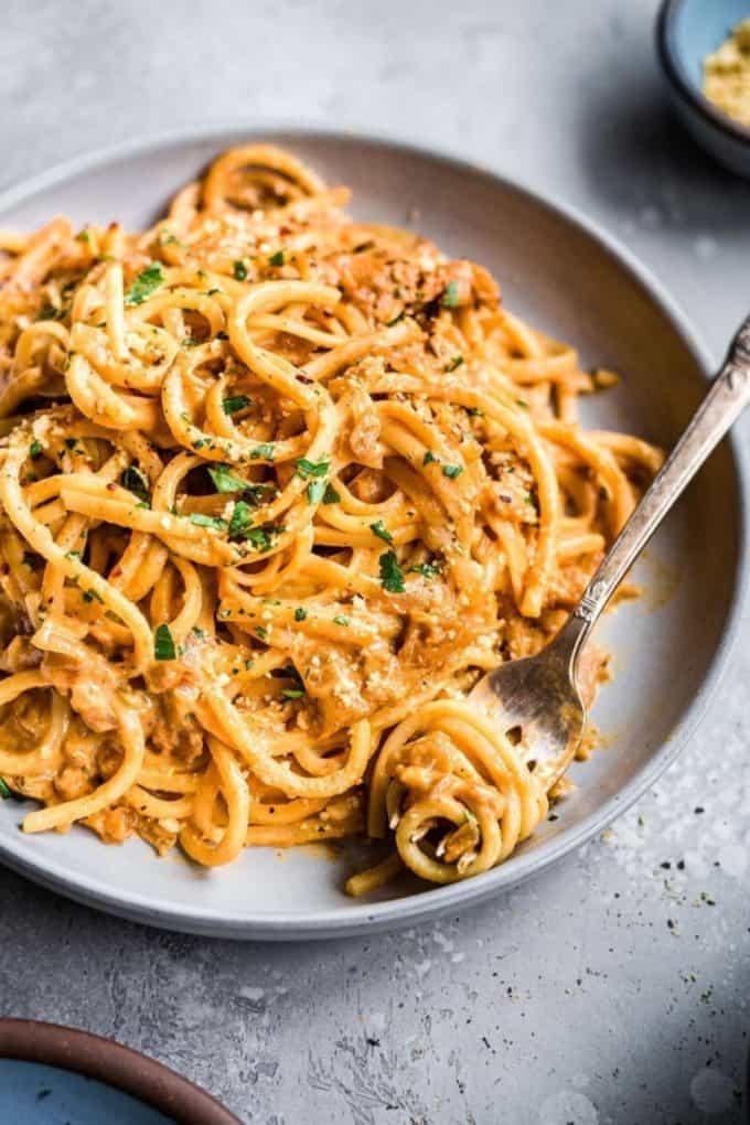 creamy spaghetti on a grey plate with a fork