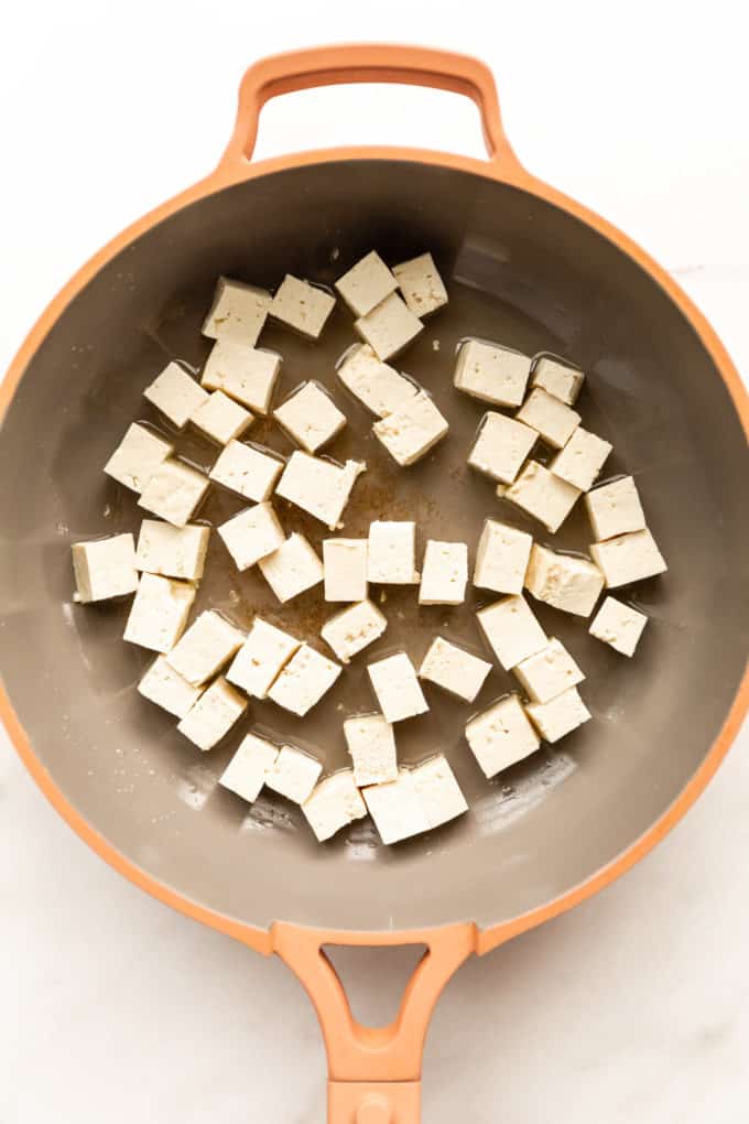 uncooked cubes of tofu in a pink pan