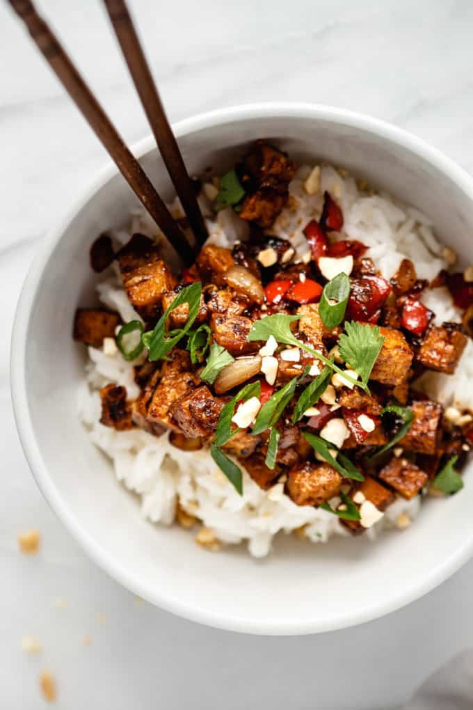 a bowl of kung pao tofu topped with green onions