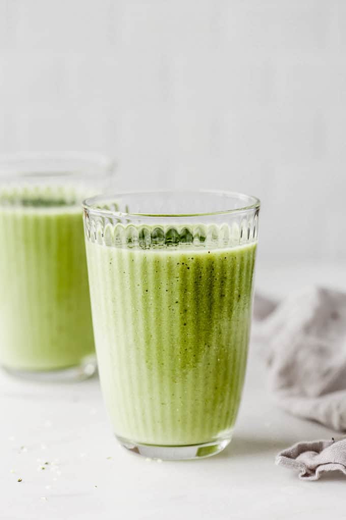 two matcha smoothies on a marble counter