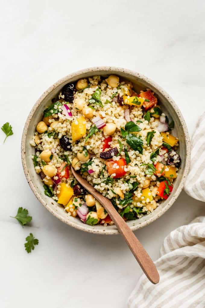 a bowl of quinoa chickpea salad with a striped napkin on the side
