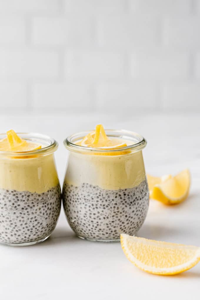 two cups of lemon chia pudding on a marble countertop