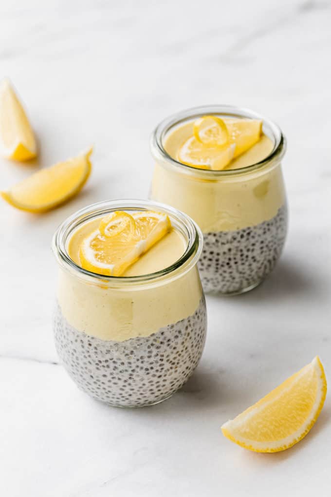 two cups of lemon chia pudding topped with slices of lemons