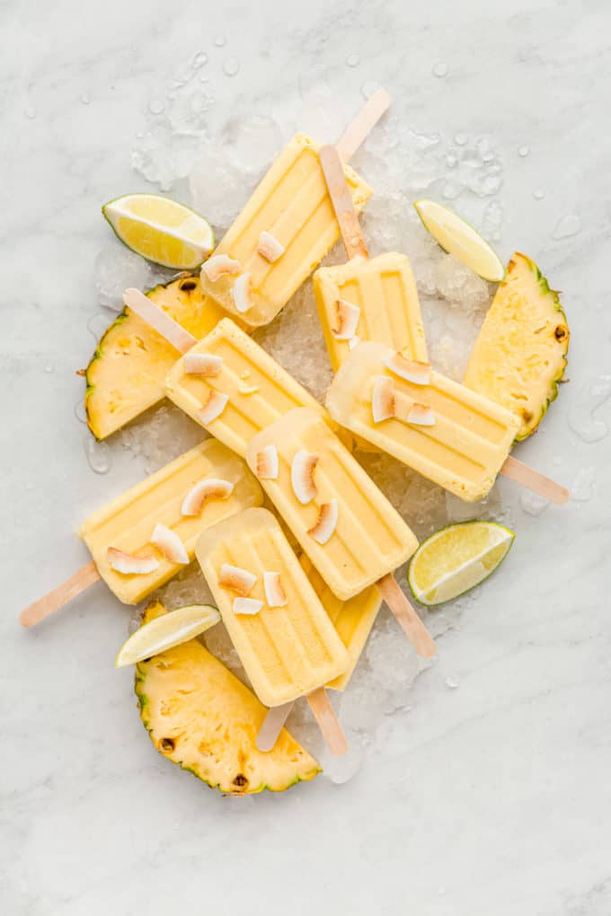 pina colada popsicles with slices of pineapples and limes