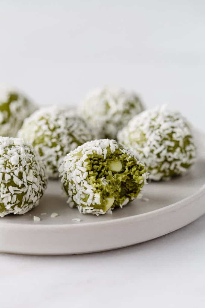 matcha balls coated in coconut on a white plate