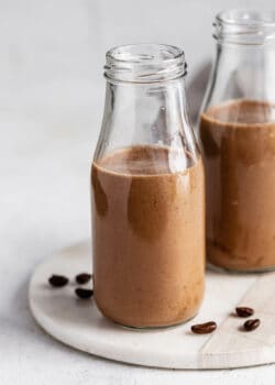 Two jars of coffee smoothie on a marble tray