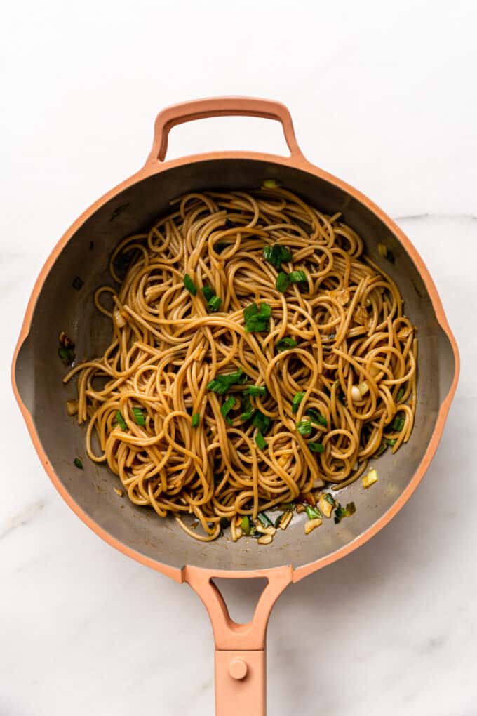 a pink pan with garlic noodles in it