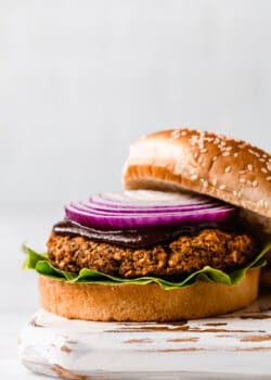 a lentil burger topped with bbq sauce and red onion