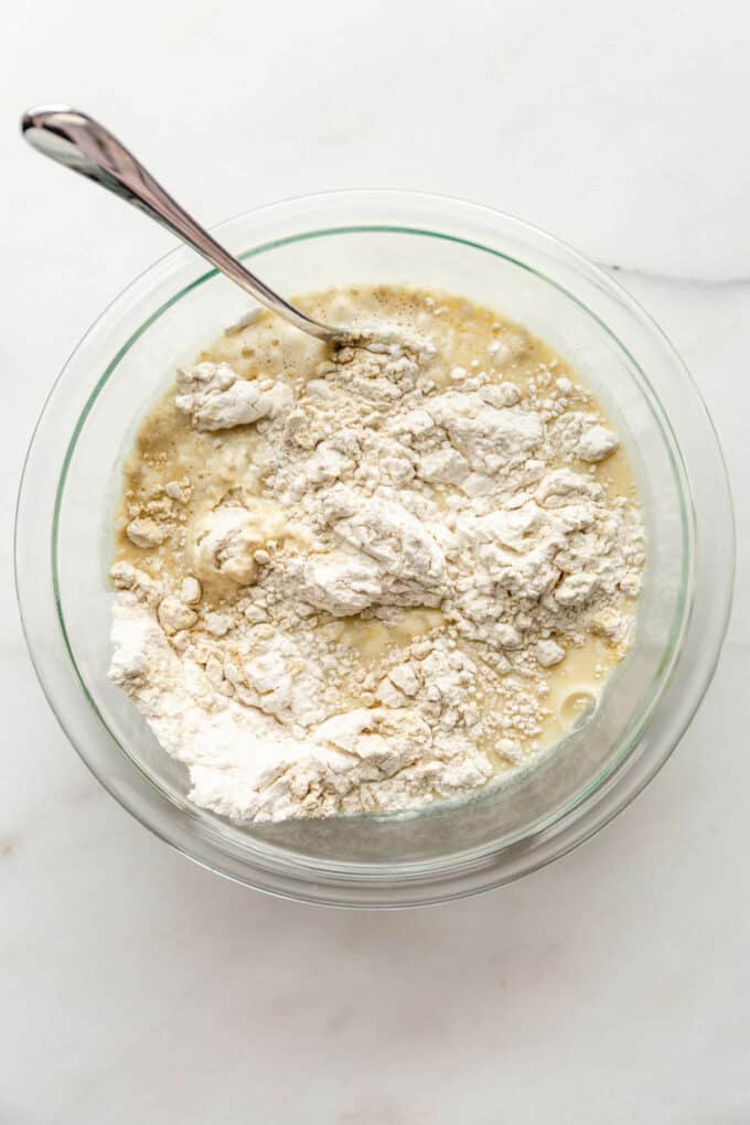 flour in a bowl with whisked eggs and milk