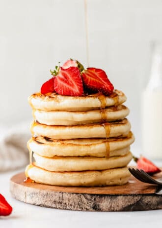 a stack of protein pancakes with maple syrup being poured on them
