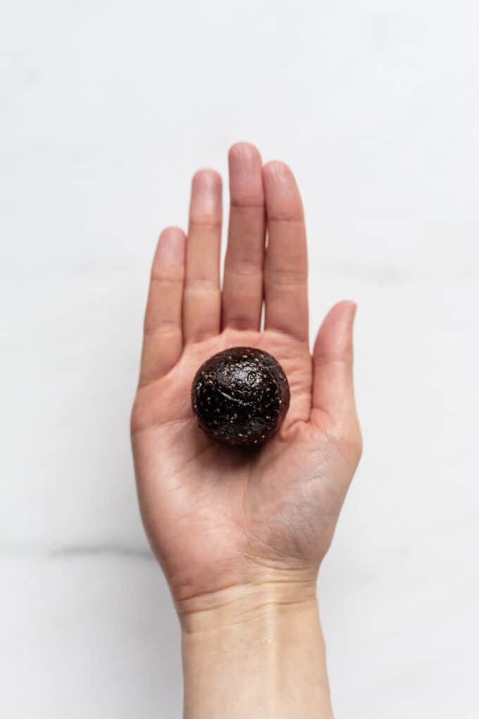 a chocolate date ball in a hand